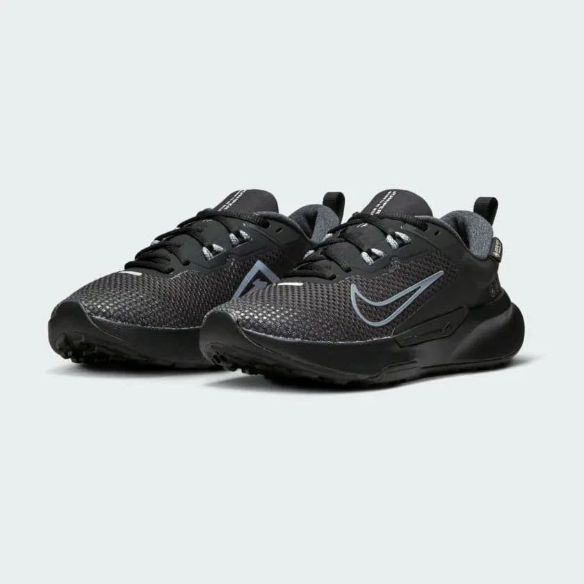 Angled view of two Nike Juniper Trail 2 Gore-Tex Women's black trainers, side by side, showcasing their robust design and athletic silhouette.