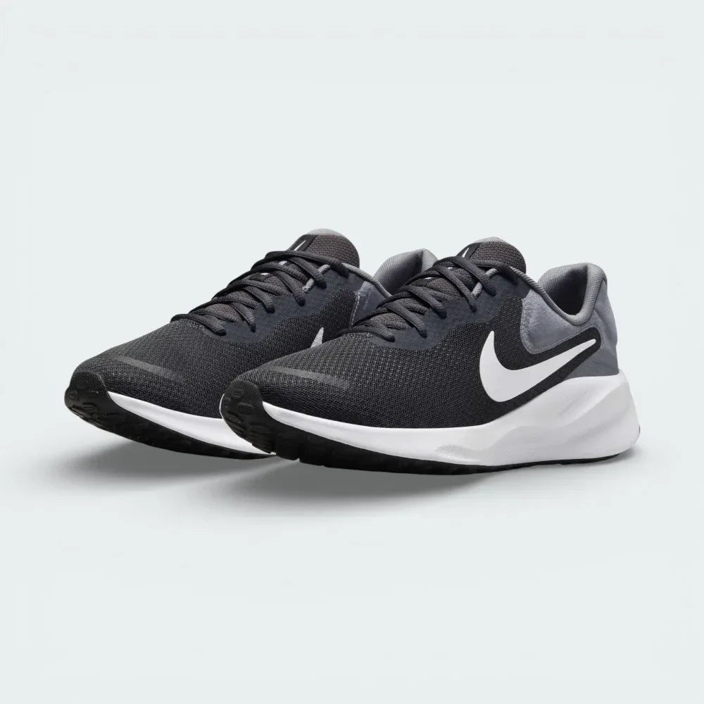 Angled shot of both Nike Revolution trainers side by side, showcasing the sleek aerodynamic silhouette and the tonal grey color layers.