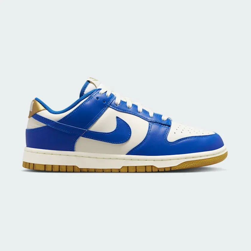 Nike Dunk Low Women's White Leather Trainers FB7173-141 side view showing white leather upper with light blue Swoosh and classic cupsole