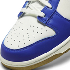 Close-up of Nike Dunk Low Women's White Leather Trainers FB7173-141 showing smooth leather texture, stitching, and tongue branding