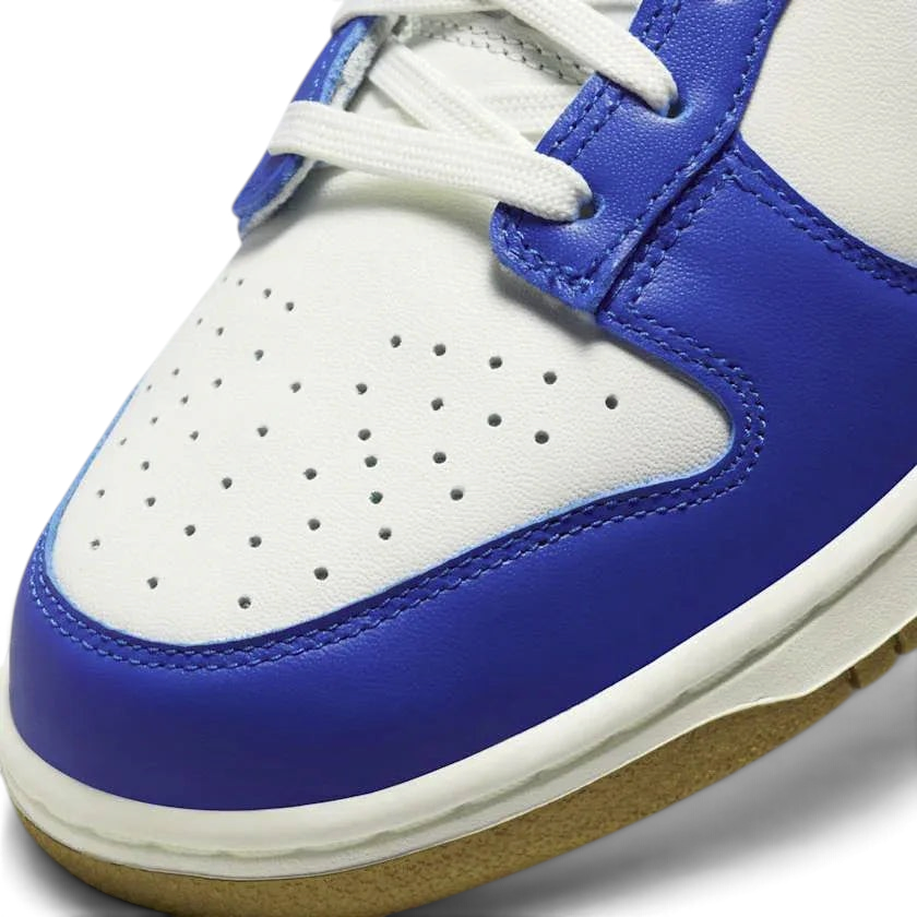 Close-up of Nike Dunk Low Women's White Leather Trainers FB7173-141 showing smooth leather texture, stitching, and tongue branding