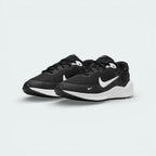 Angled shot of both Nike Revolution 7 trainers side by side, showcasing the sleek, athletic silhouette and high-contrast black and white design.