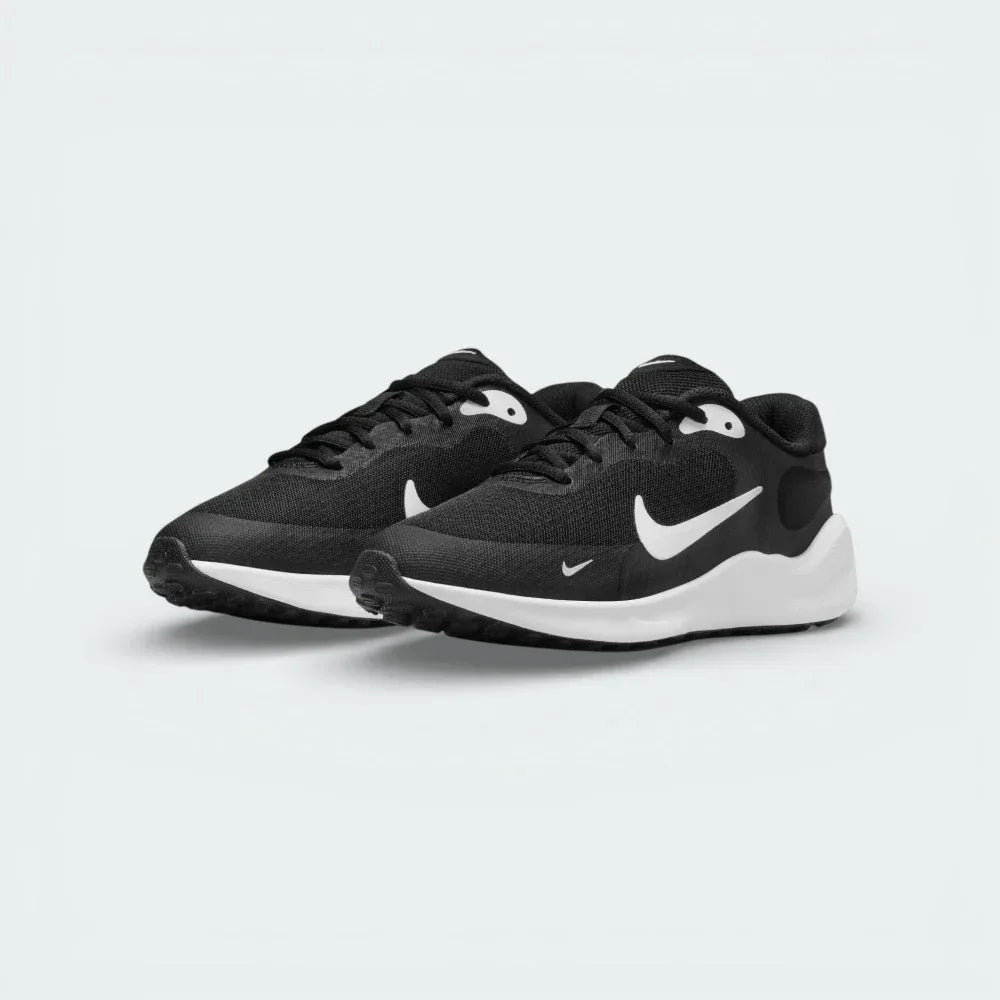 Angled shot of both Nike Revolution 7 trainers side by side, showcasing the sleek, athletic silhouette and high-contrast black and white design.