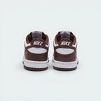 Focuses on the contoured shape of the padded low-cut collar, highlighting the clean embroidered Nike block text stitched squarely into the deep Redwood rear heel overlay panel.