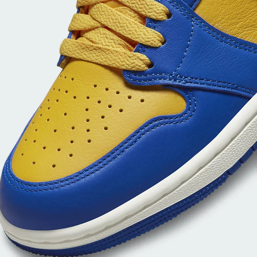 Close-up zoom on the front of the Air Jordan 1 Hi Retro OG Women's yellow and blue trainers, showing the perforated toe box, lacing system, and textured leather upper.
