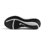 Full-length bottom profile showing the solid rubber outsole, highlighting the multi-directional road traction pattern, longitudinal flex siping grooves, perimeter grip pods, and debossed central Nike Swoosh.