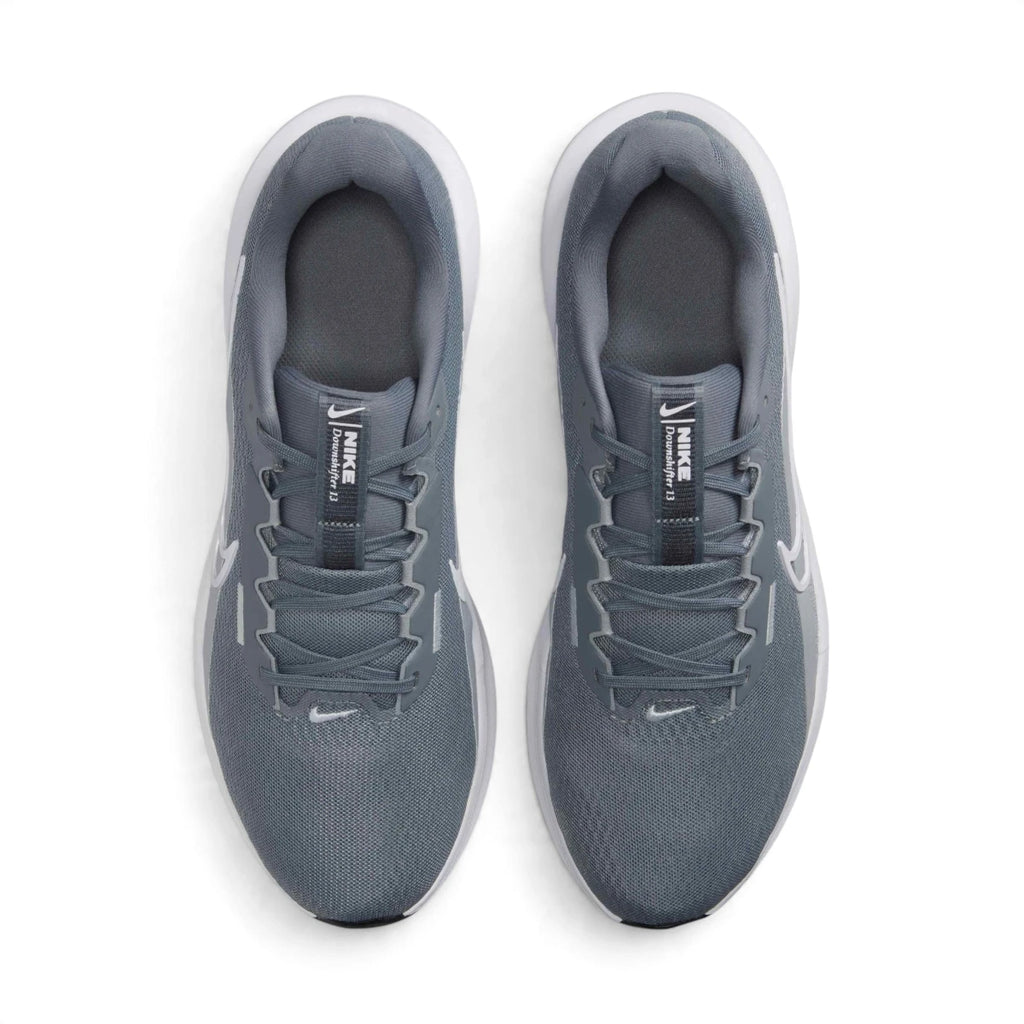 Direct overhead view of both shoes laid flat, showcasing the airy open-mesh toe box, flat tonal laces threaded through reinforced eyestays, internal midfoot fit band construction, padded mesh tongue with Downshifter crest badging, and cushioned interior sockliners.