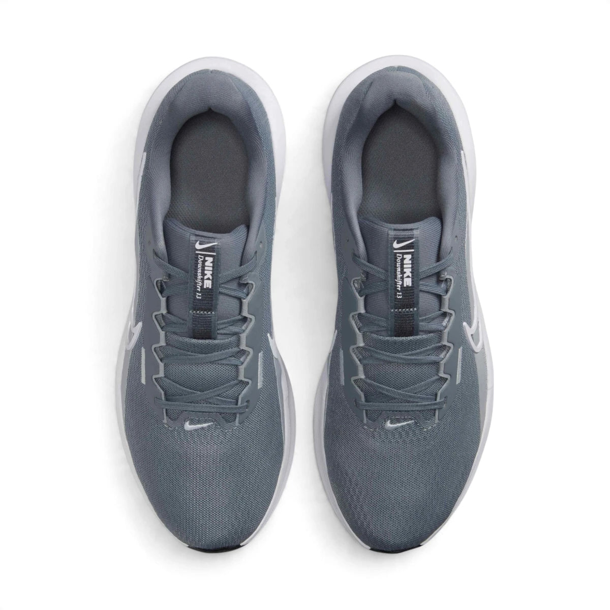 Direct overhead view of both shoes laid flat, showcasing the airy open-mesh toe box, flat tonal laces threaded through reinforced eyestays, internal midfoot fit band construction, padded mesh tongue with Downshifter crest badging, and cushioned interior sockliners.