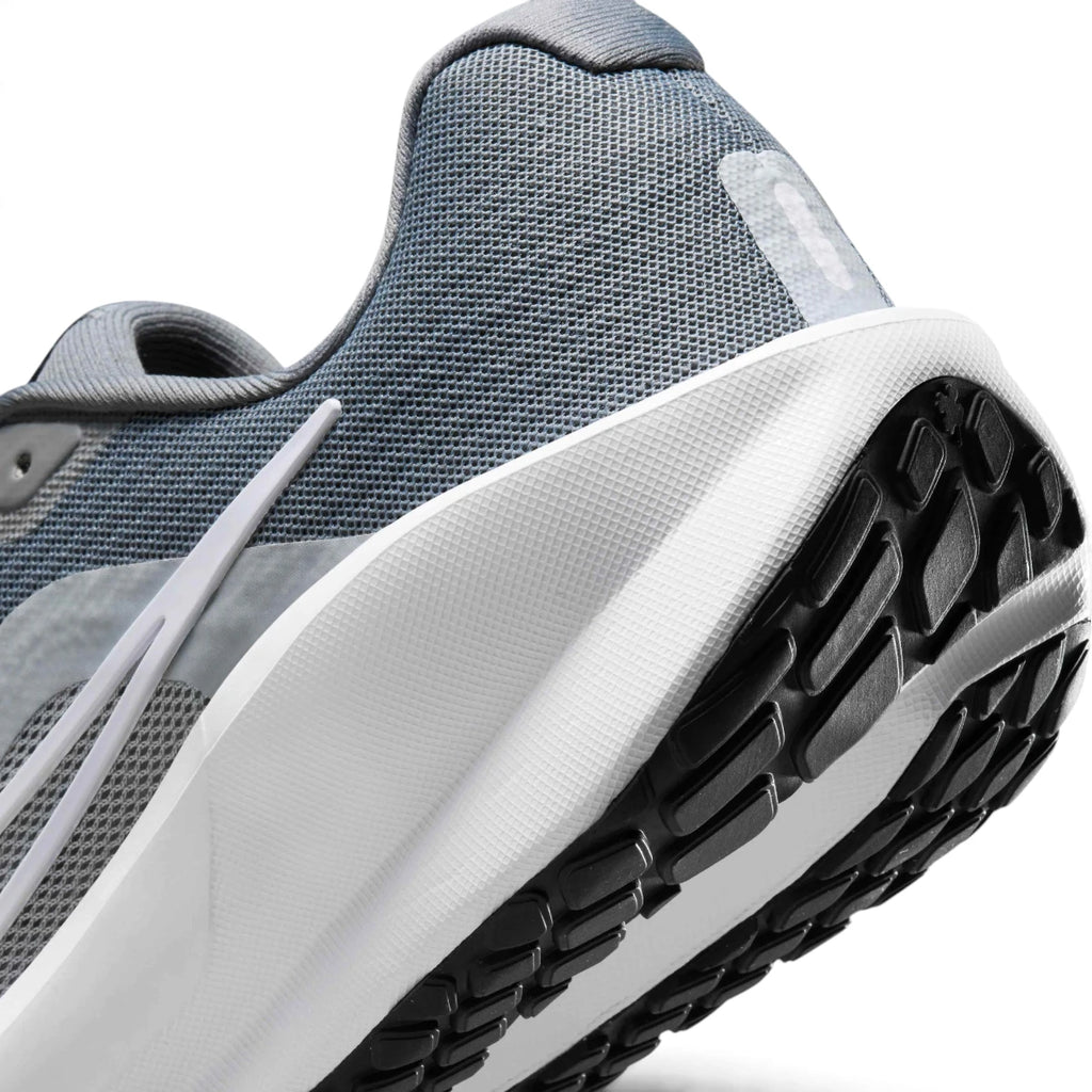 Sculpted Plush Foam Midsole Sidewall Texture, Clean White Swoosh Tail Overlay, Wolf Grey Midfoot Reinforcements, and High-Traction Road Rubber Tread Lugs, demonstrating the shock-absorbing foam depth and road-tested tooling.