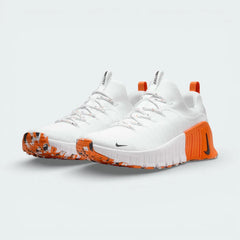 Angled shot of both Nike Free Metcon trainers side by side, showcasing the athletic silhouette and high-contrast orange and black detailing.