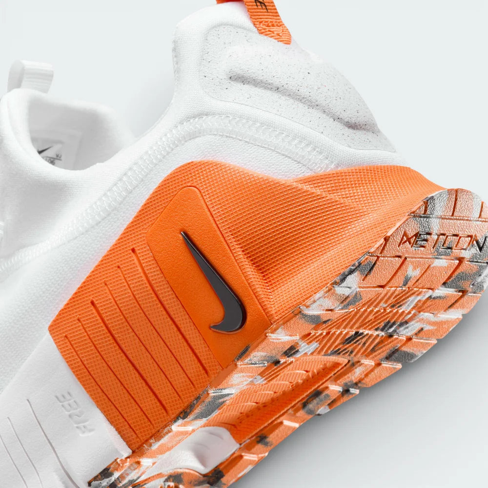 Detailed zoom on the midsole area, highlighting the dual-density cushioning and the vibrant orange rubber wrapping on the sidewalls.