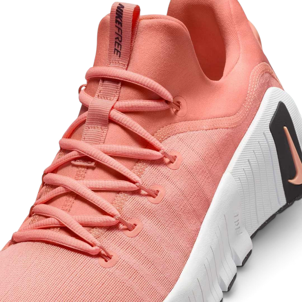 Close-up zoom on the front of the Nike Free Metcon 5 Men's orange training shoes, showing the breathable mesh upper texture, lacing system, and flexible toe area.