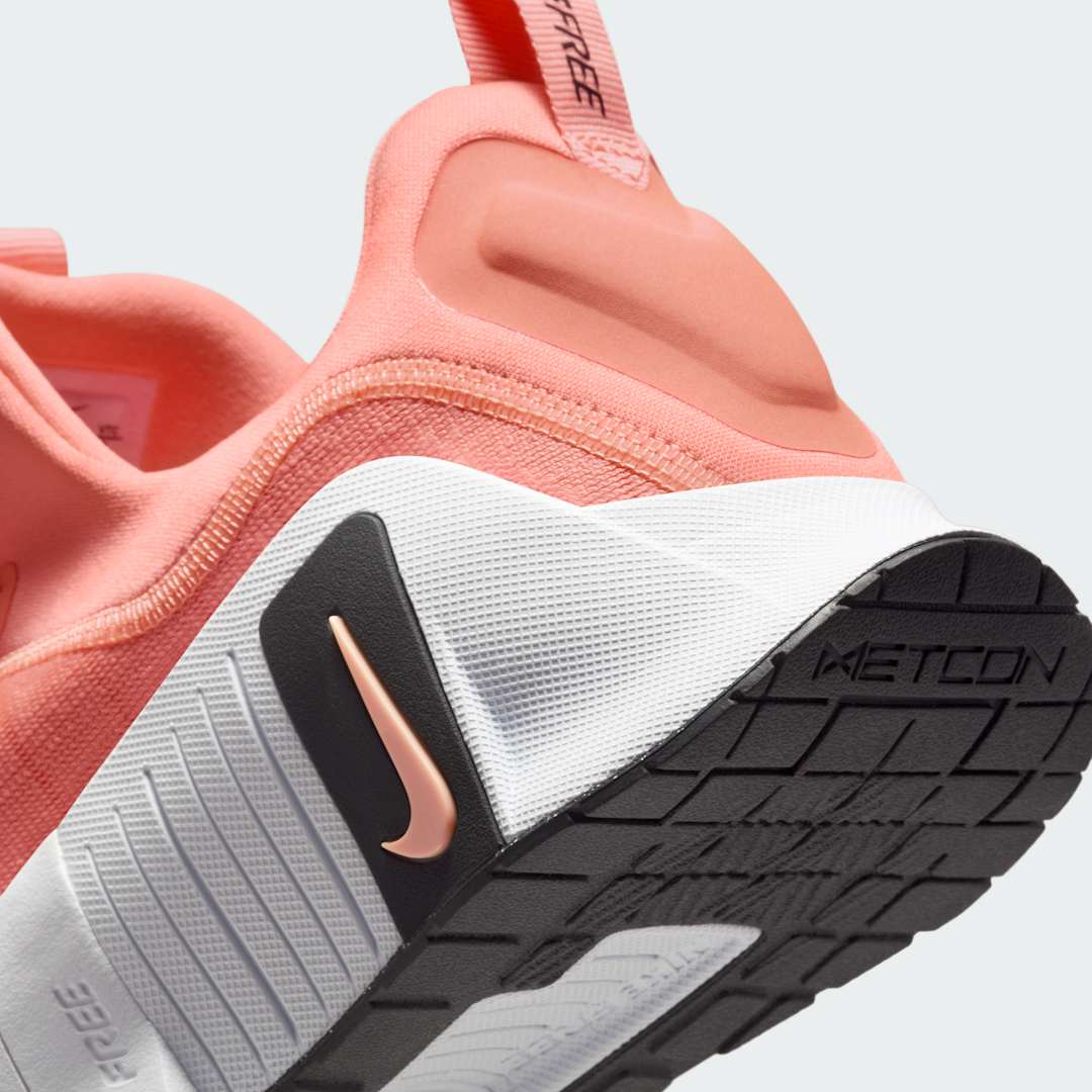Detailed zoom on the outsole and midsole of the Nike Free Metcon 5 Men's orange training shoes, highlighting the dual-density cushioning and durable rubber for versatile training.