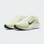 Three-quarter front angle view showing both Nike Air Winflo 11 shoes side by side, showcasing their athletic running stance, off-white mesh uppers, and bright lime green highlights.