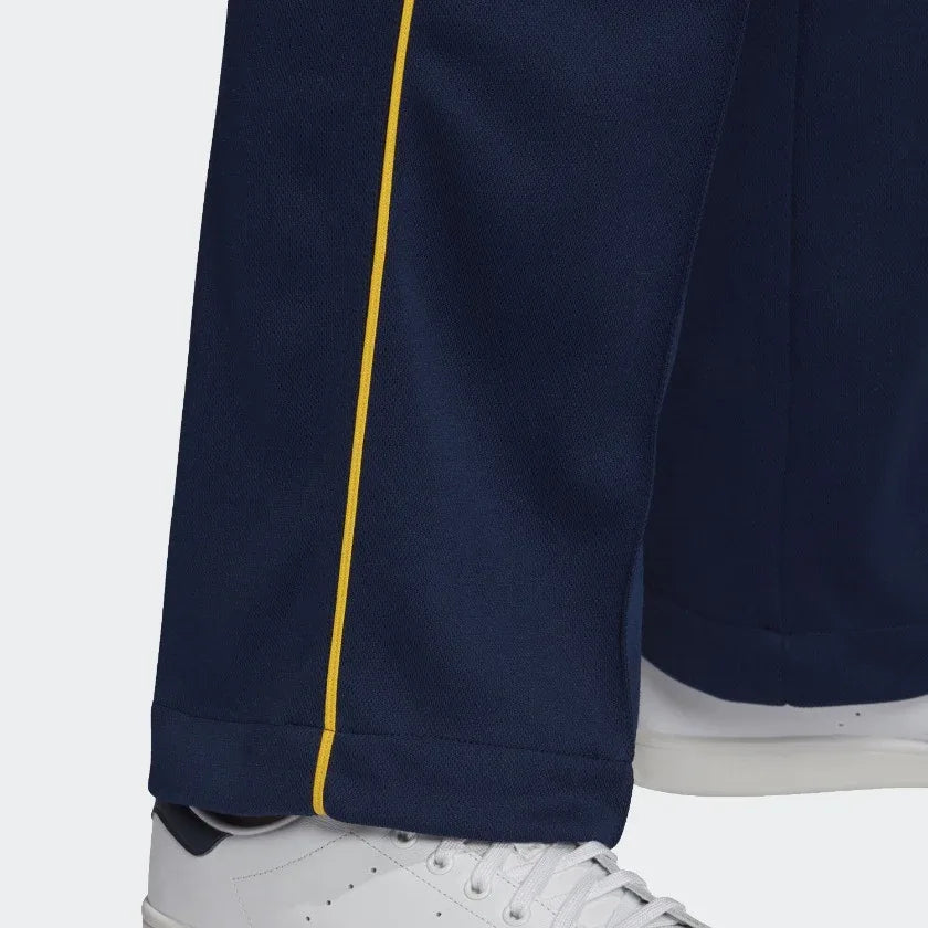Close-up zoom on the Adidas Recycled Track Pants Men's in dark blue, showing the smooth fabric texture and the embroidered Adidas Trefoil logo.
