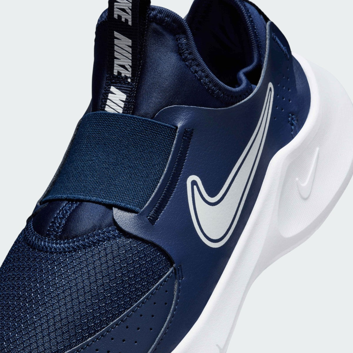 Close-up zoom on the front of the Nike Flex Runner 3 Juniors' navy trainers, showing the mesh upper texture and the laceless entry.