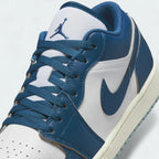 Close-up zoom on the front of the Air Jordan 1 Low Special Edition Men's white trainers, showing the perforated toe box, lacing system, and textured leather upper.