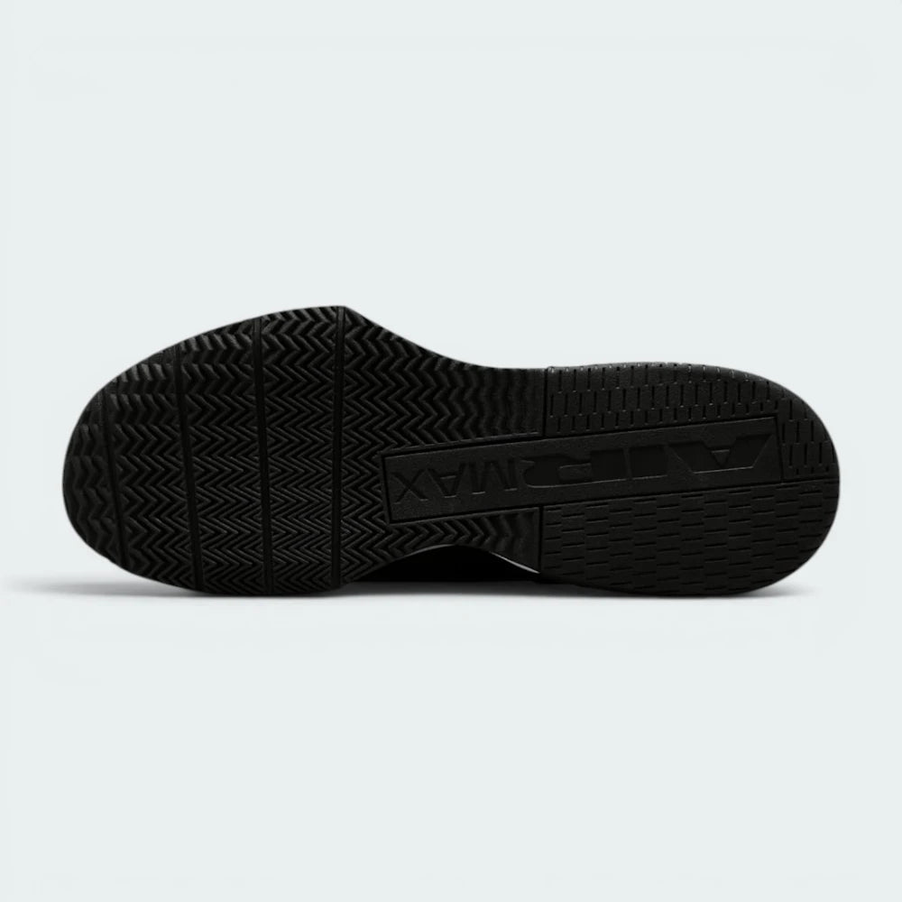 Displays the flat-profile geometric traction pattern of the solid black rubber sole, highlighting the deep forefoot flex grooves engineered for unreal lunge flexibility and premium mat grip.