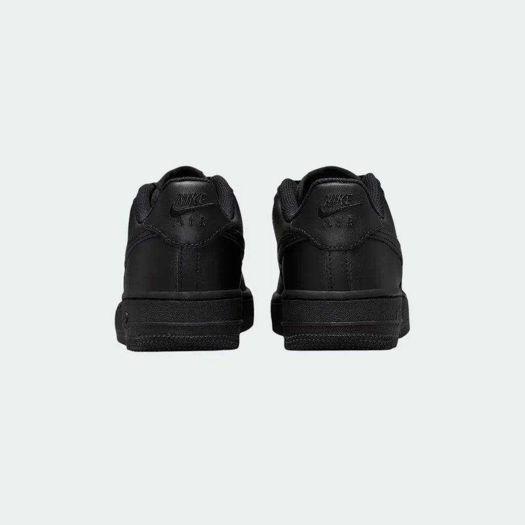 Rear view of the Nike Air Force 1 Juniors' black trainers, focusing on the heel panel and Nike Air branding.