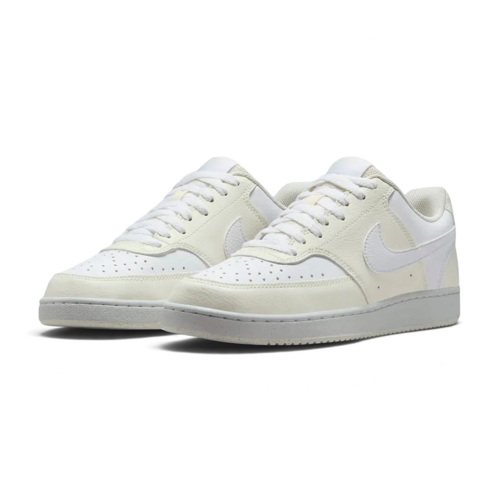 Angled view of two Nike Court Vision Lo Next Nature Women's trainers in white and white, side by side, showcasing their clean aesthetic and retro style.