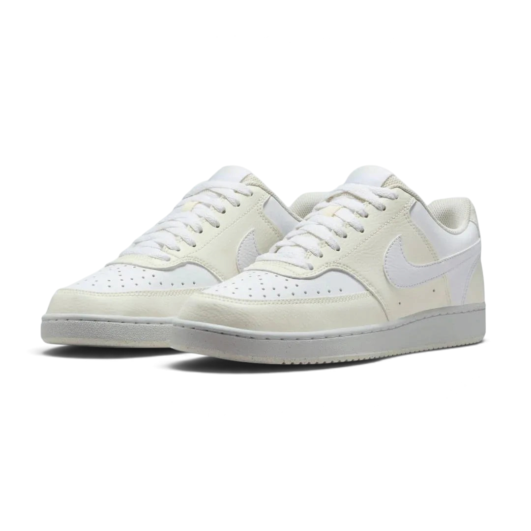 Angled view of two Nike Court Vision Lo Next Nature Women's trainers in white and white, side by side, showcasing their clean aesthetic and retro style.