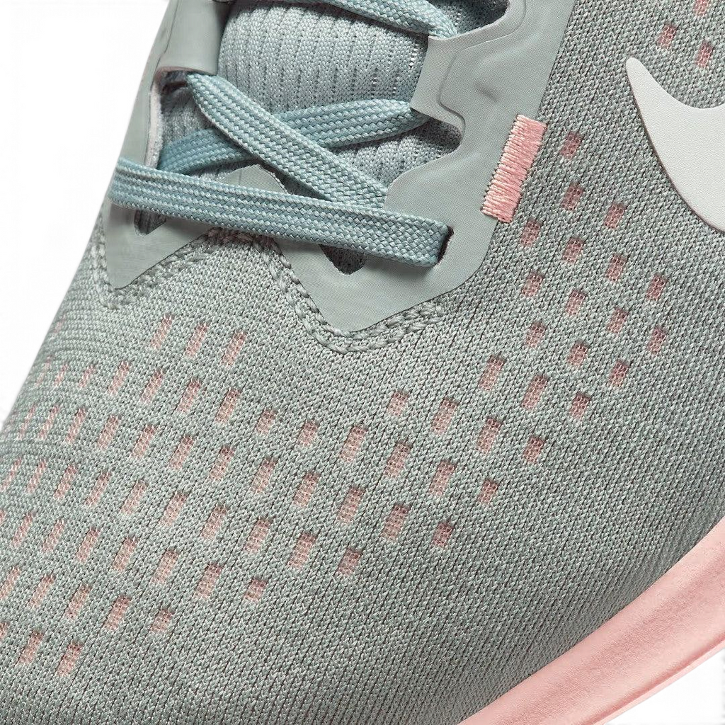 Close-up zoom on the front of the Nike Air Winflo 10 Women's green running shoes, showing the mesh upper texture, lacing system, and synthetic overlays.