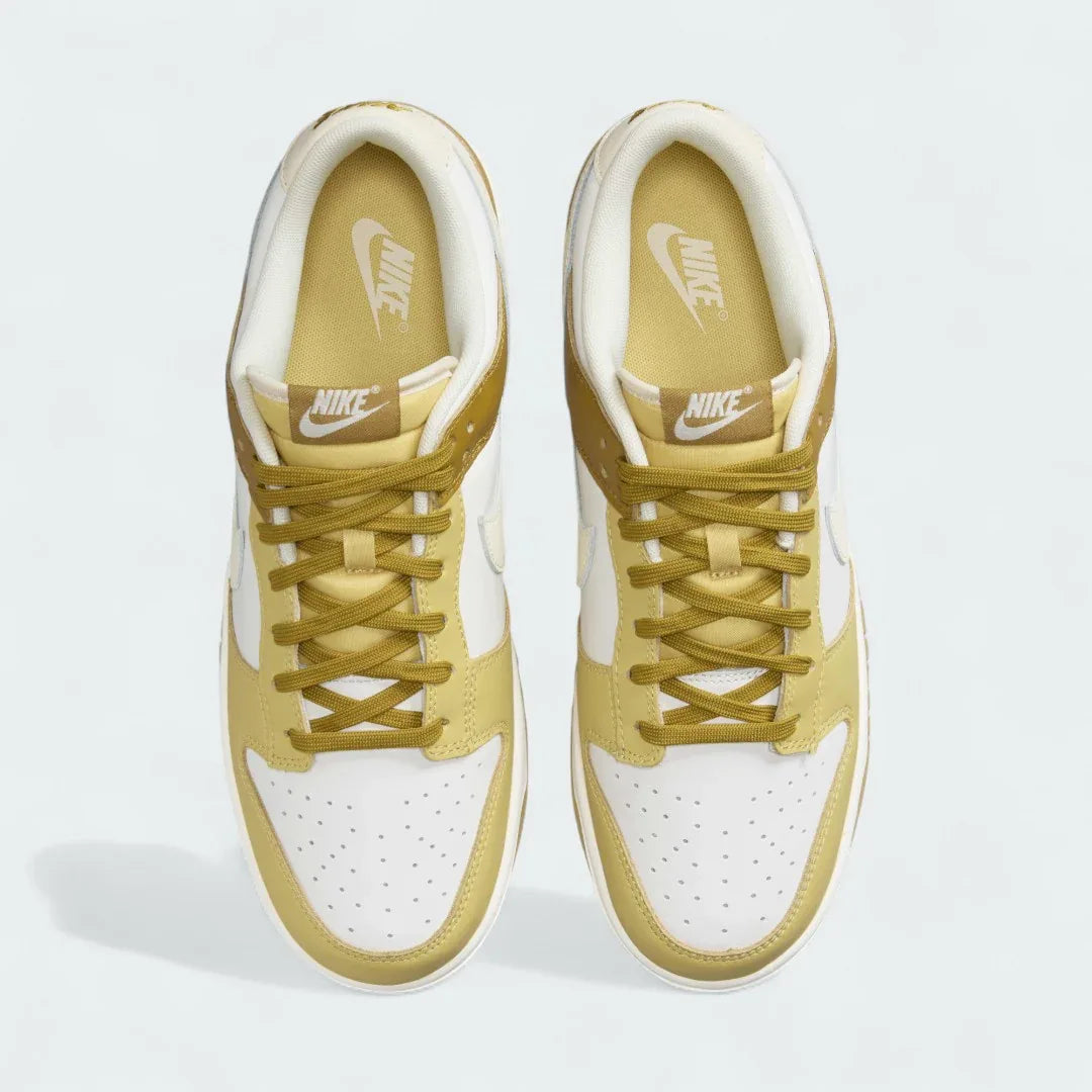 Top-down view of a pair of Nike Dunk Low Retro Men's sneakers in bronzine and coconut milk, highlighting their iconic silhouette and lace-up closure.