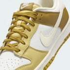 Close-up zoom on the front of the Nike Dunk Low Retro Men's bronze sneakers, showing the perforated toe box, lace-up system, and textured leather upper.
