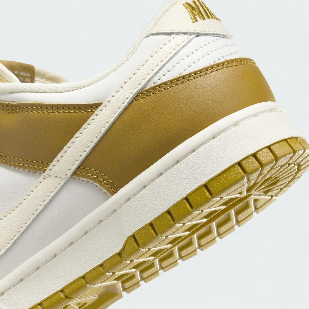 Detailed zoom on the outsole and midsole of the Nike Dunk Low Retro Men's bronze sneakers, highlighting the cushioned foam and durable rubber outsole.