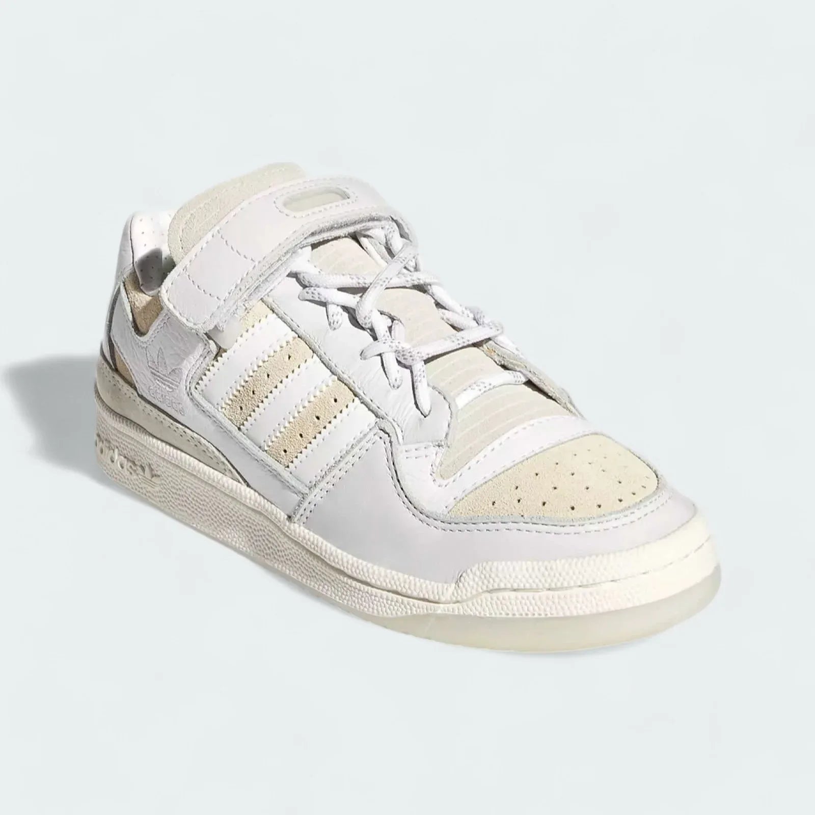 Angled view of Adidas x Ivy Park Forum Low women's trainers in white, side by side, showcasing their iconic silhouette and bold design.