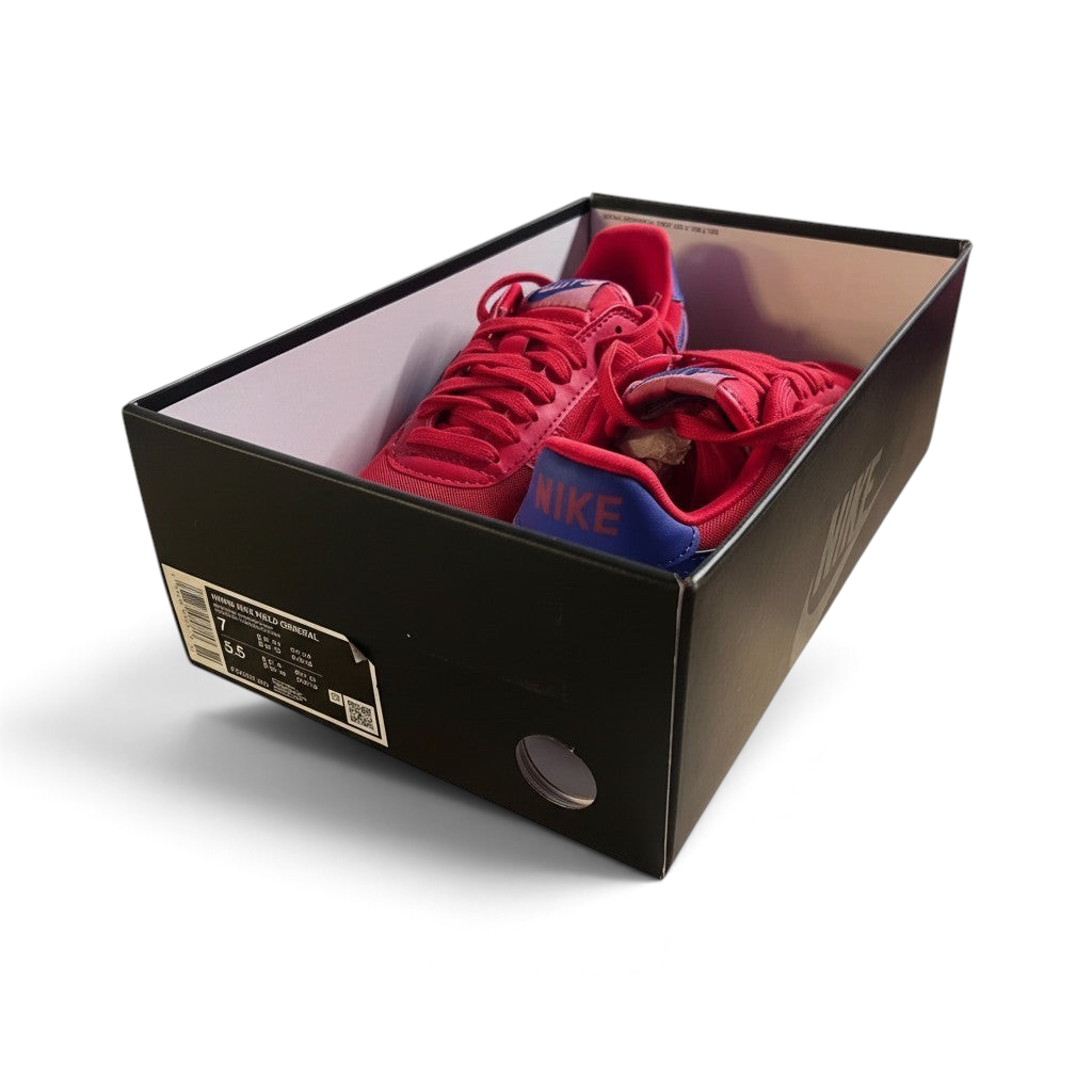 Red sneakers inside a black shoe box on a white background