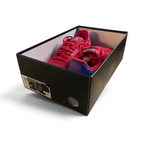Red sneakers inside a black shoe box on a white background