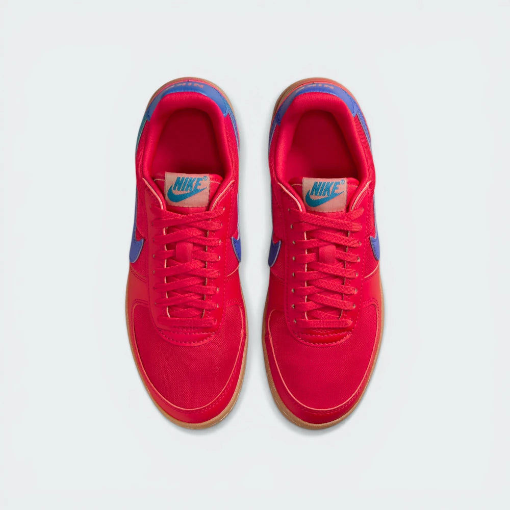 Looking down at the red lacing system, the woven textile panels, and the archival Nike branding on the tongue.