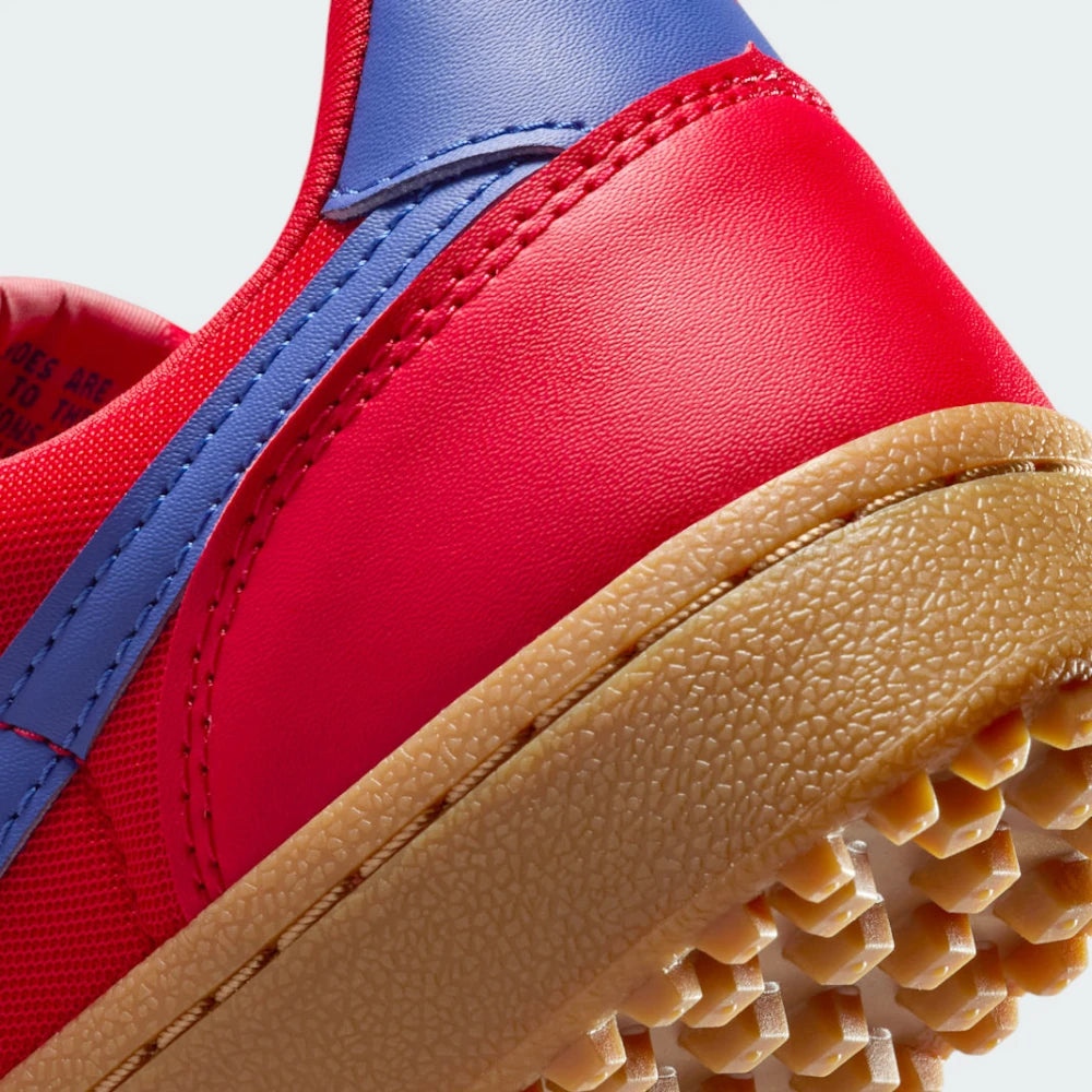 Highlighting the transition between the cushioned white foam midsole and the classic rubber waffle lugs.