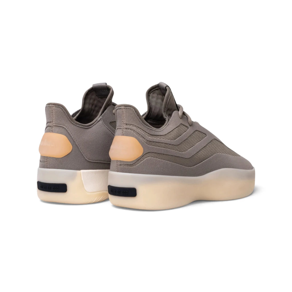Rear-facing perspective focusing on the tonal heel pull detail, curved collar shape, and the black rubber heel bar embossed with the Fear of God logo.