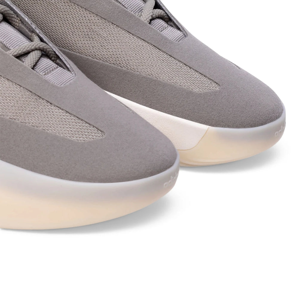 Macro focus on the fine-grained synthetic material texture, breathable monofilament side stripes, and the embossed adidas logo on the toe.