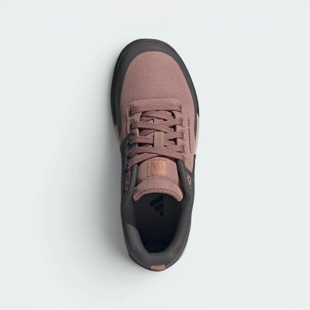 Focuses on the locked-in traditional lacing layout, displaying the perfect symmetry of the canvas tongue, the elastic lace-keep band, and the smooth, unstitched arc of the impact-resistant toe box.