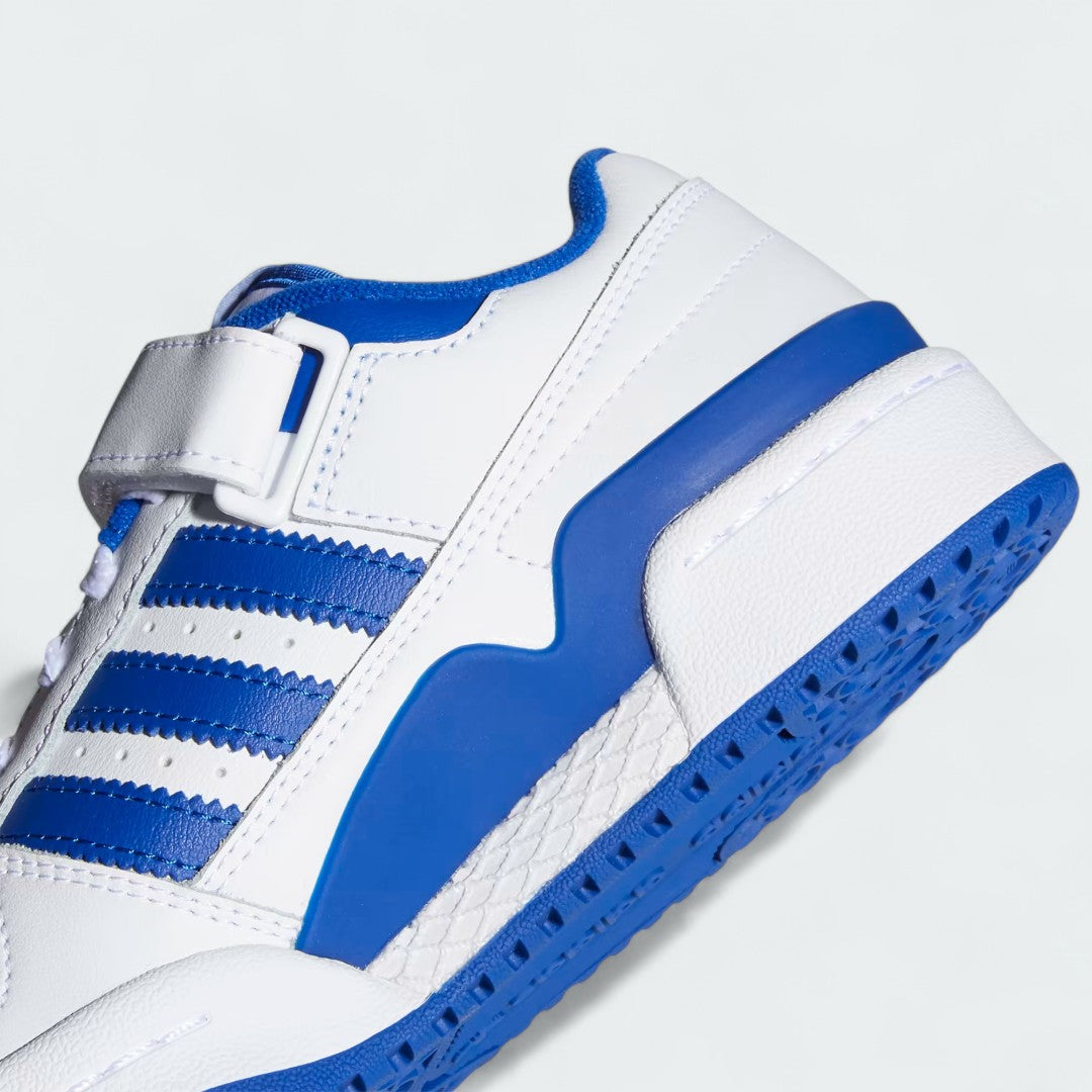 Detailed zoom on the ankle strap and midsole of the Adidas Forum Low Juniors' white trainers, highlighting the hook-and-loop closure and stitched rubber cupsole.