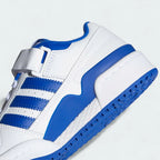 Detailed zoom on the ankle strap and midsole of the Adidas Forum Low Juniors' white trainers, highlighting the hook-and-loop closure and stitched rubber cupsole.