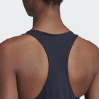 Person wearing a navy blue tank top on a light gray background