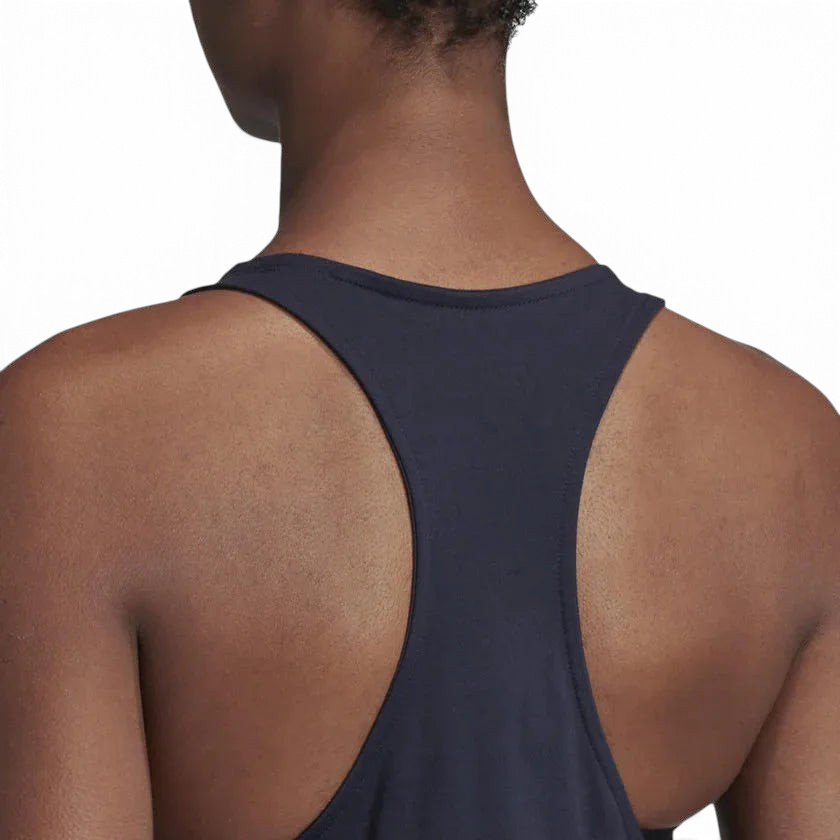 Person wearing a navy blue tank top on a light gray background