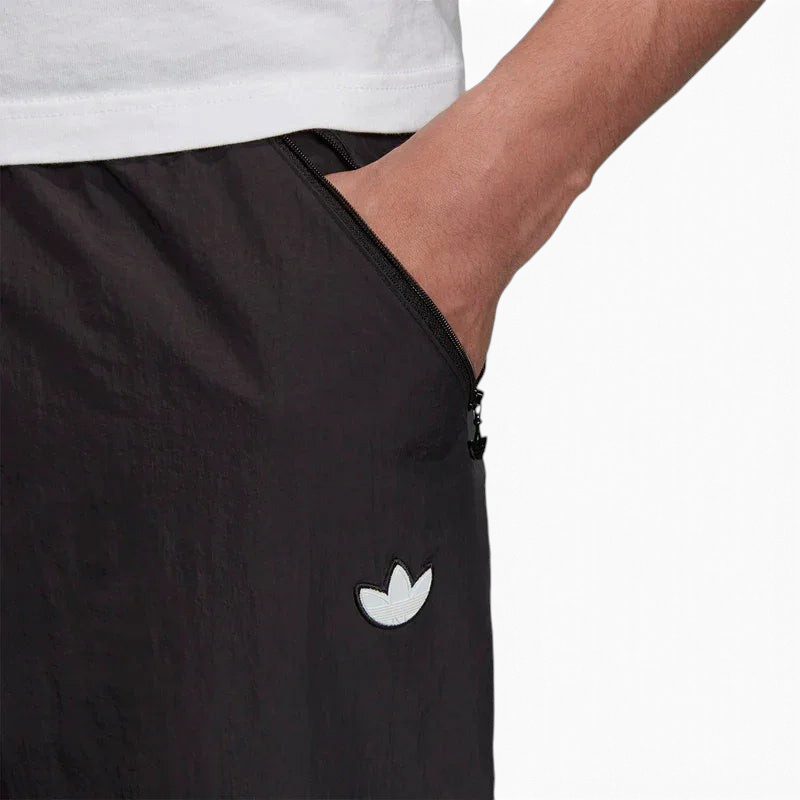 lose-up zoom on the Adidas Tolima 02 Men's Track Pants in black nylon, showing the smooth fabric texture and the Adidas logo detail on the thigh.
