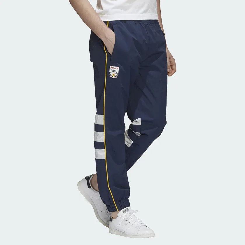 Adidas Arsenal 91-93 Track Pants Men's in collegiate navy, front view showing elastic waistband, red 3-Stripes down the legs, and embroidered Arsenal FC crest. Main image