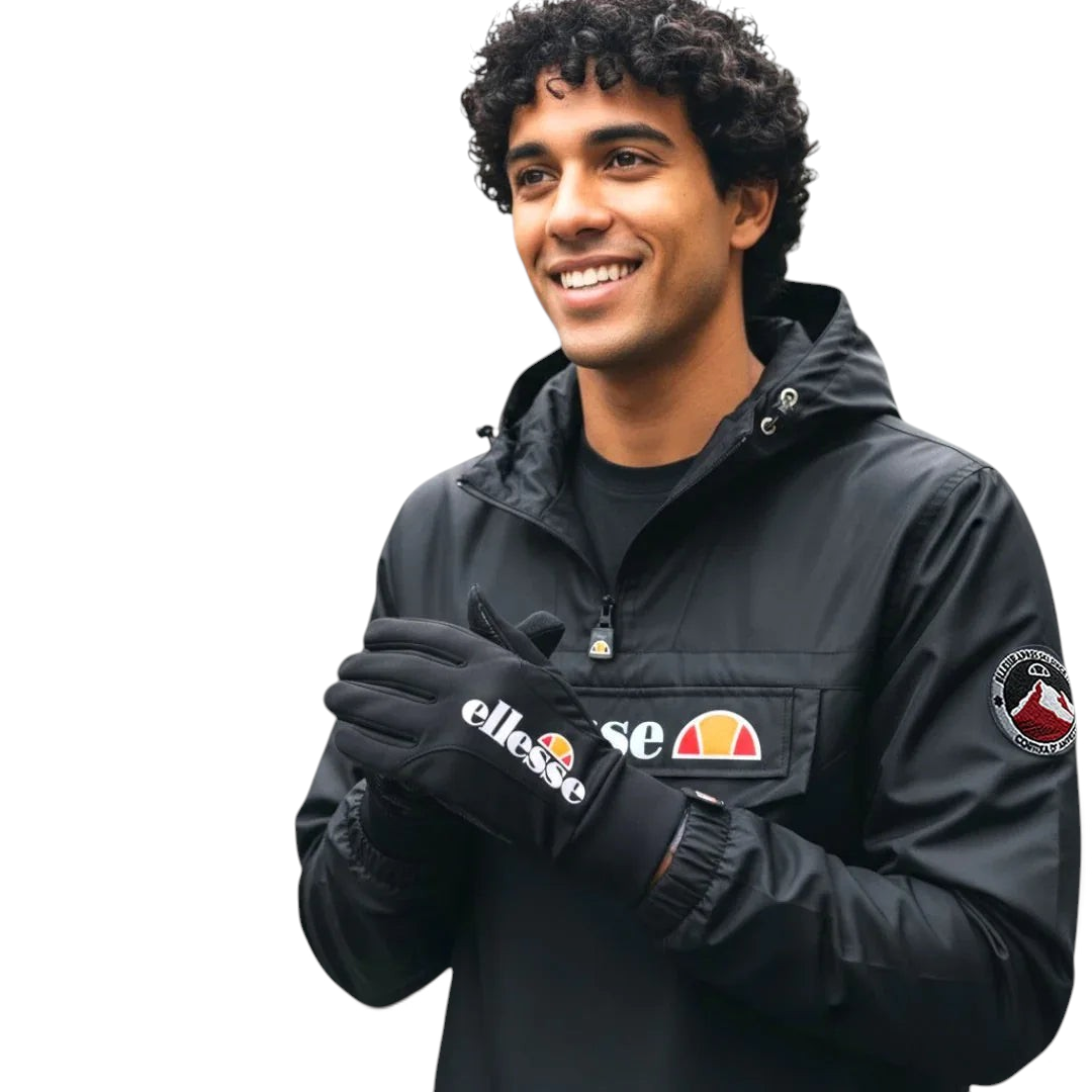 A hand wearing the Ellesse Daxo Touchscreen Glove in black, demonstrating its snug fit and the ability to use a smartphone with the glove on. Main image