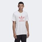 A man wearing a white Adidas t-shirt with a pink Trefoil logo on the front.