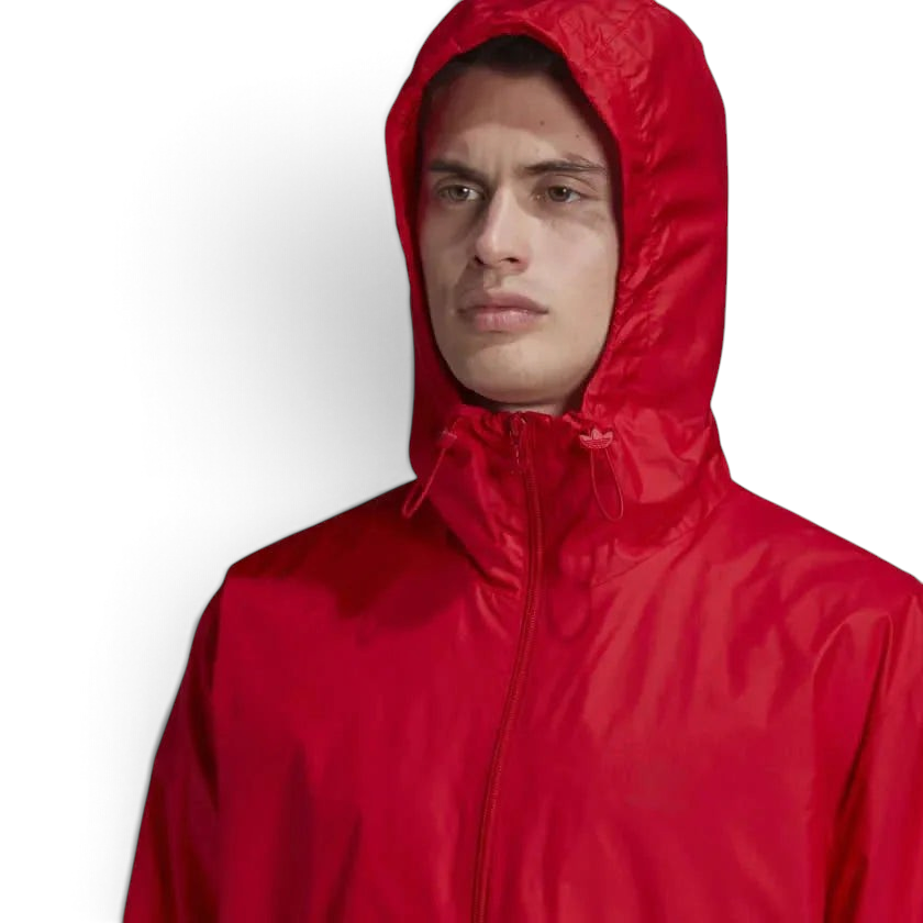 Trade Sports model wearing a scarlet red Adidas Originals windbreaker with a hood and full-zip front closure.