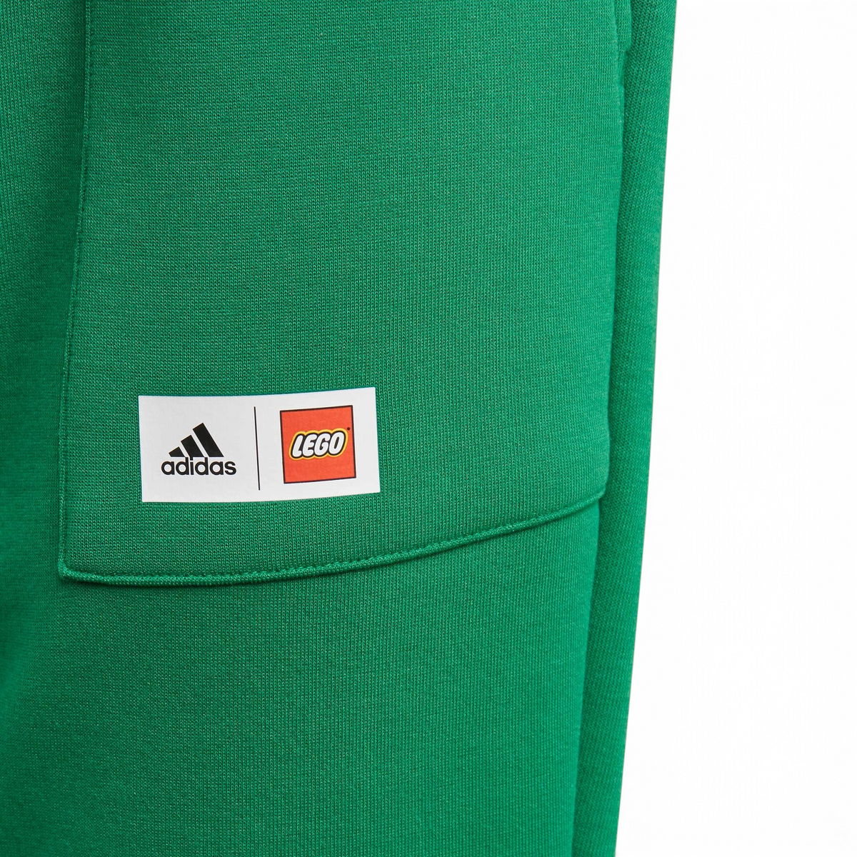 Close-up of adidas x LEGO Kids' Fleece Track Pants GN6803 elastic waist with LEGO logo