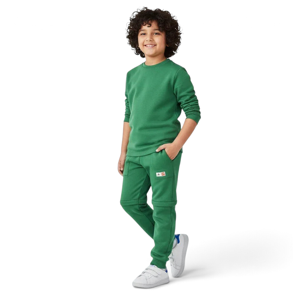 Trade Sports child wearing green adidas x LEGO fleece track pants with zip-off legs and matching green sweatshirt. Main image