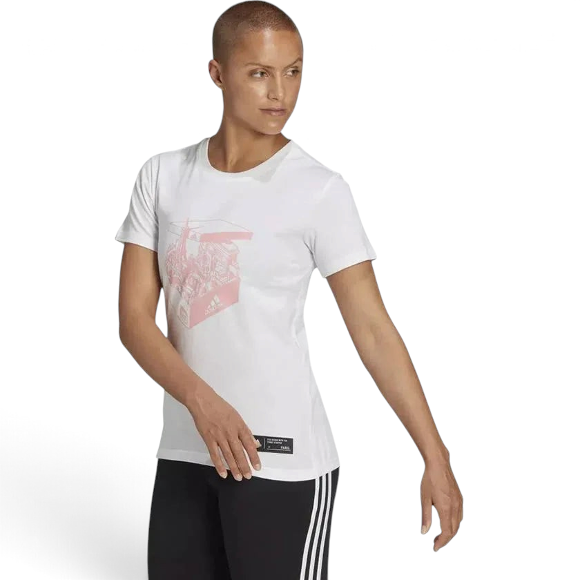 A woman wearing a white Adidas t-shirt with a graphic design, paired with black pants with a side stripe.