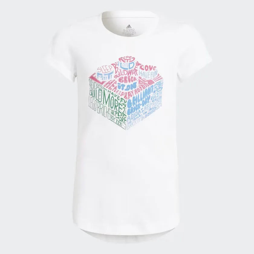 White Adidas x Lego girls graphic t-shirt with colorful Lego pieces and text design on the front. Main image